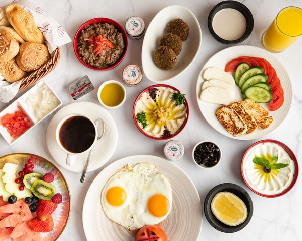 A breakfast spread with various foods and drinks. - Mysk Al Mouj Hotel (Muscat)