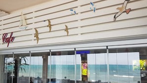 Ein Hotel an der Küste, mit einem Schild, auf dem "Hotel 8 Cule" steht, und Vogel- sowie Segelmotive als Dekoration.
