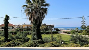 Un barrio residencial con una palmera alta, un césped cuidado y casas con vistas al mar.