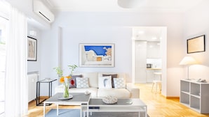 A modern living room with a sofa, coffee table, and a painting on the wall. - Athens Squared Lofts (Athens)