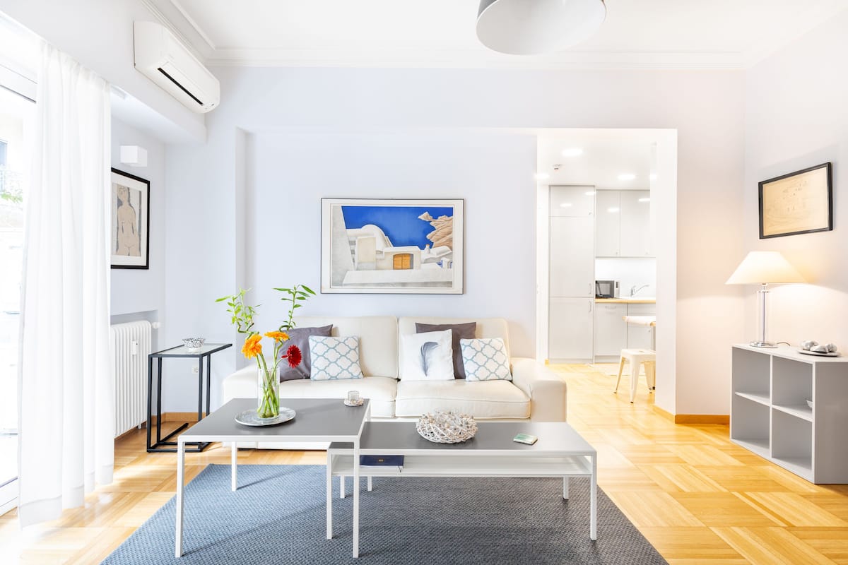 A modern living room with a sofa, coffee table, and a painting on the wall.