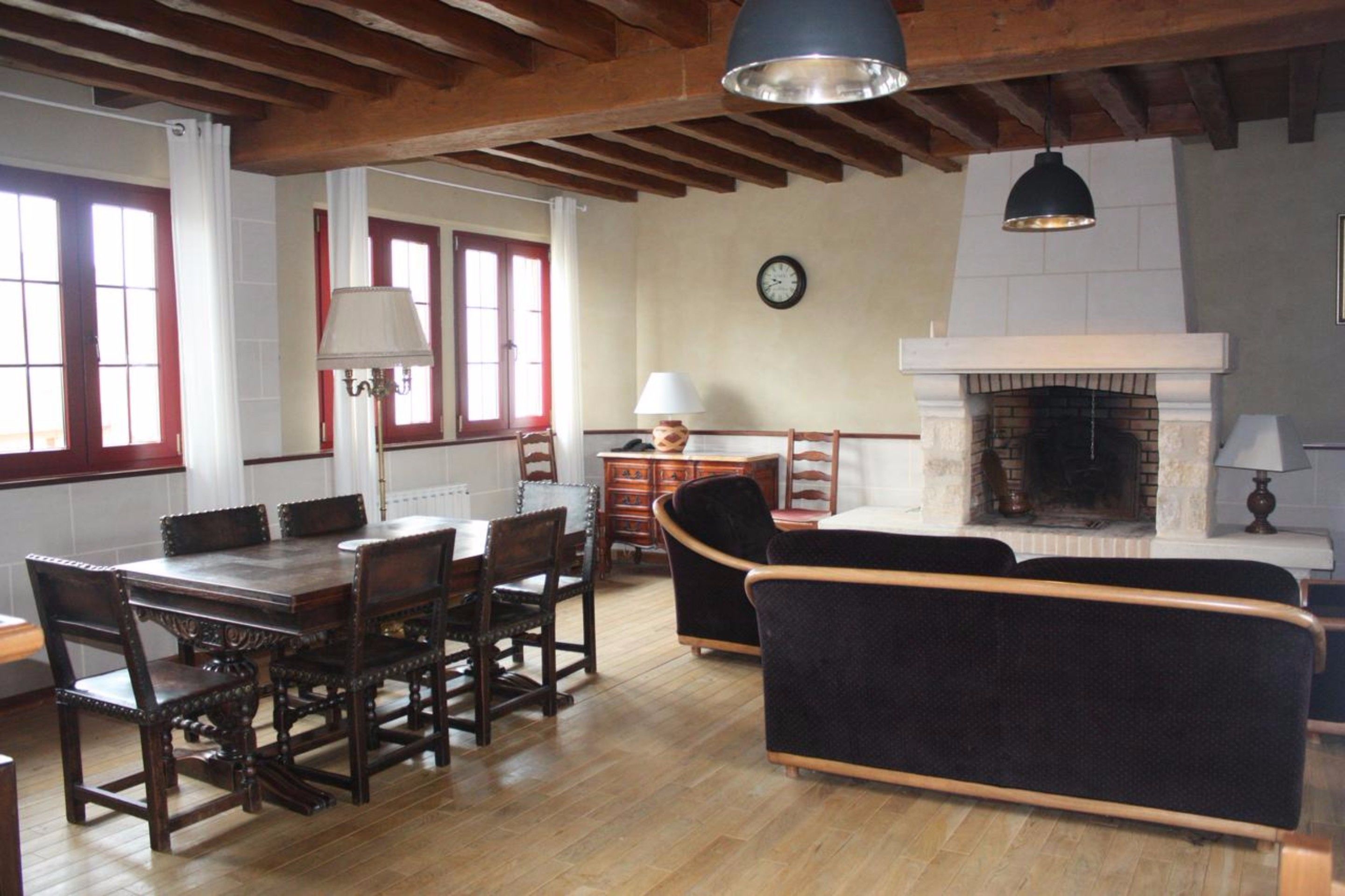 Una zona pranzo con tavolo e sedie in legno, un divano e un camino.