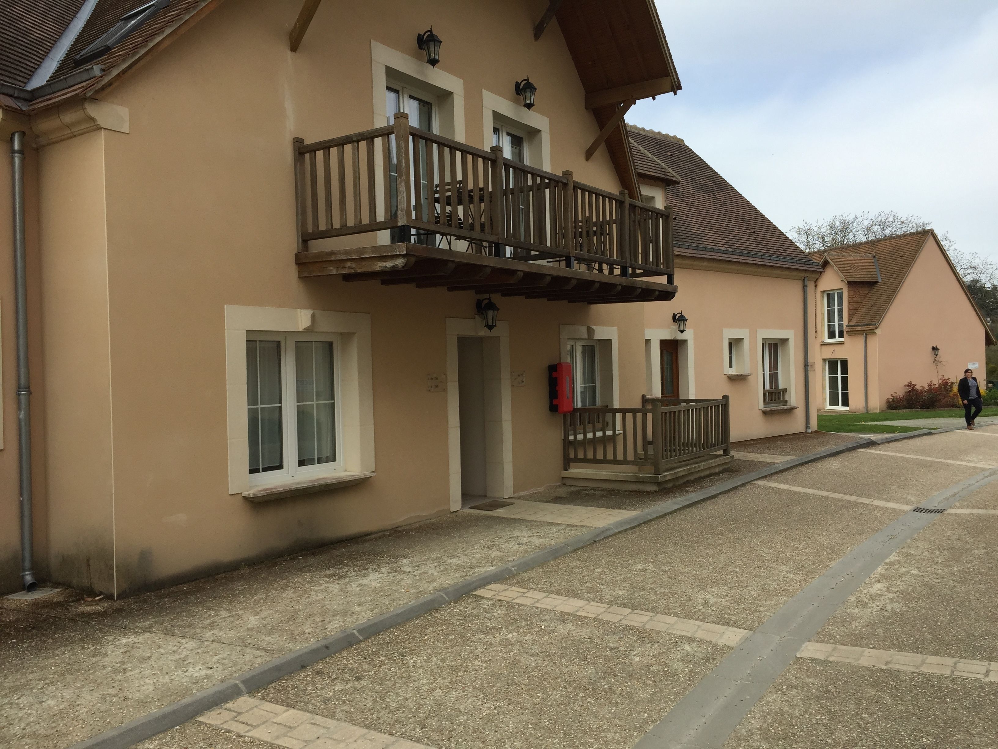 Un bâtiment doté d’un balcon, d’une porte et de fenêtres.