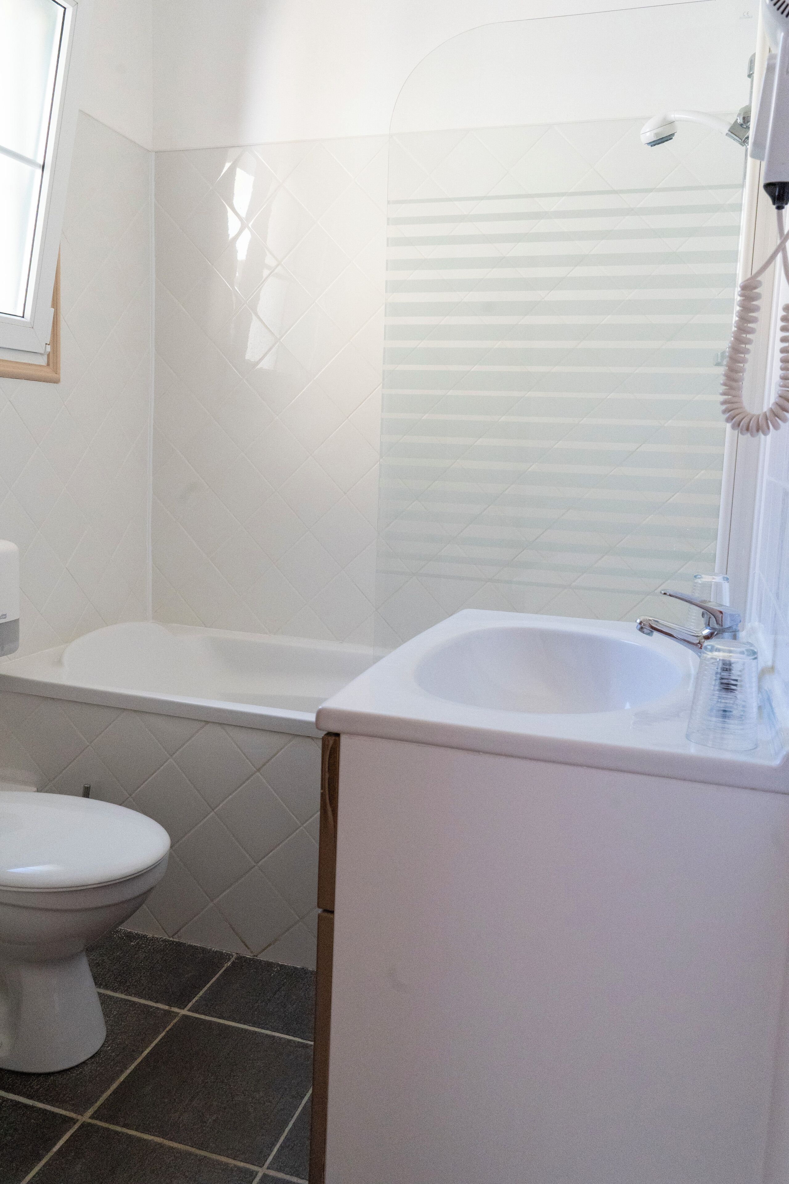 A bathroom with a white bathtub, a sink, and a toilet.