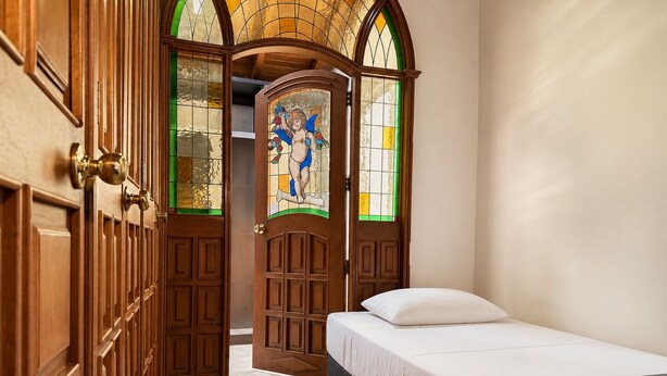 A hotel room with a bed, a wooden wardrobe, and a stained glass door. - Hotel Boutique Laureles Home (Medellín)