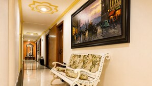A hotel corridor with a bench, a framed painting, and a mirror. - Hotel Boutique Laureles Home (Medellín)