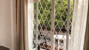 A balcony with a metal railing, a table, and chairs. - Hotel Boutique Laureles Home (Medellín)