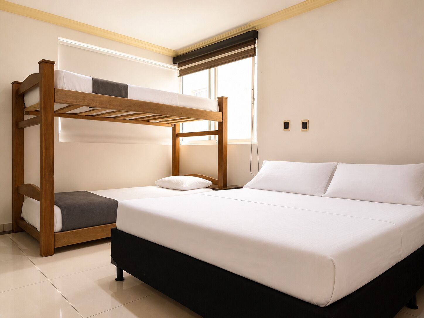 Quarto com beliche, uma cama individual e uma janela.