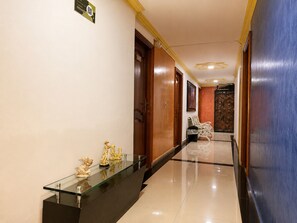 A hotel hallway with a reception desk, a bench, and a door. - Hotel Boutique Laureles Home (Medellín)