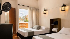 Une chambre d’hôtel avec un lit, une table de chevet, une lampe et une vue sur la ville.