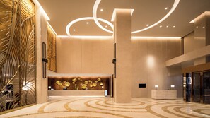 A modern lobby with a marble floor, a reception desk, and a decorative wall with circular patterns. - Holiday Inn Suzhou Taihu Lake by IHG (Suzhou)
