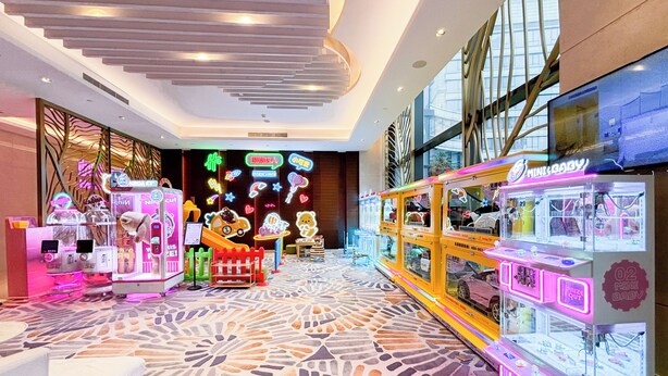A brightly lit arcade area with claw machines and neon signs, featuring a patterned floor and large windows. - Holiday Inn Suzhou Taihu Lake by IHG (Suzhou)