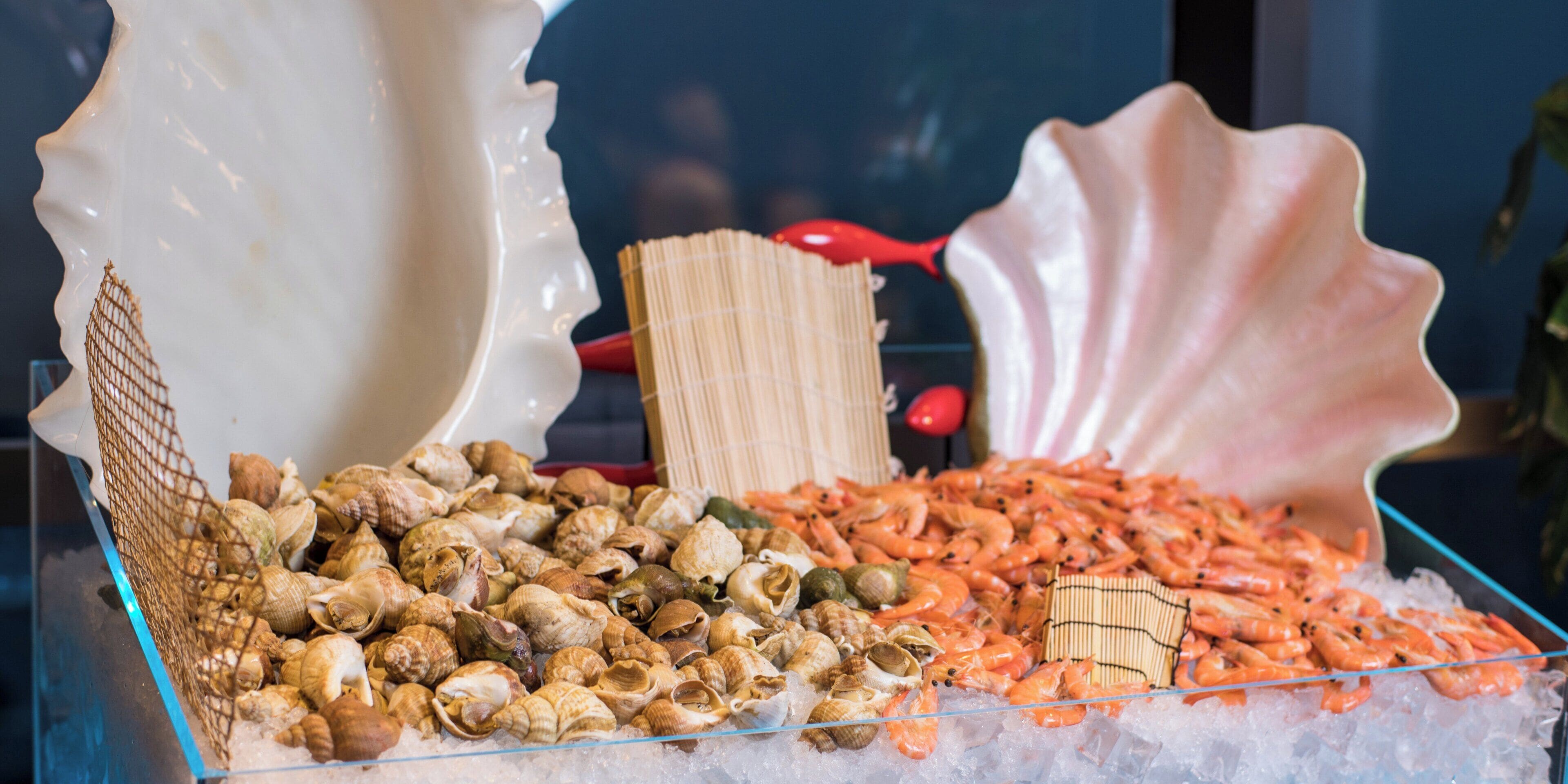 Exhibición de mariscos con diversos crustáceos y camarones sobre hielo.