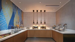 A modern kitchen with a central island, overhead pendant lights, and a decorative wall mural. - Holiday Inn Express Hangzhou East Station by IHG (Hangzhou)