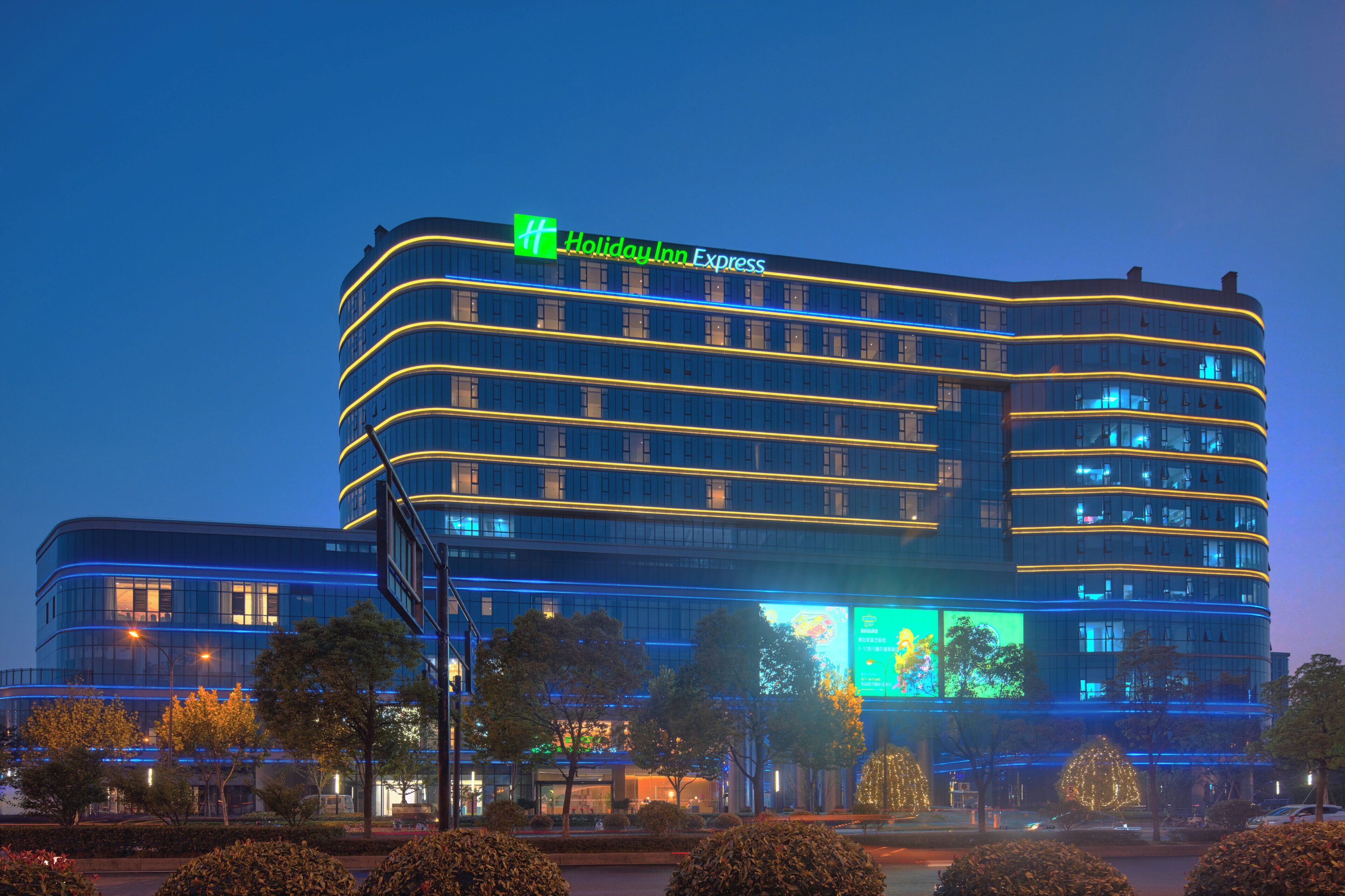 A multi-story hotel with a prominent 'Holiday Inn Express' sign, large windows, and a modern architectural design.