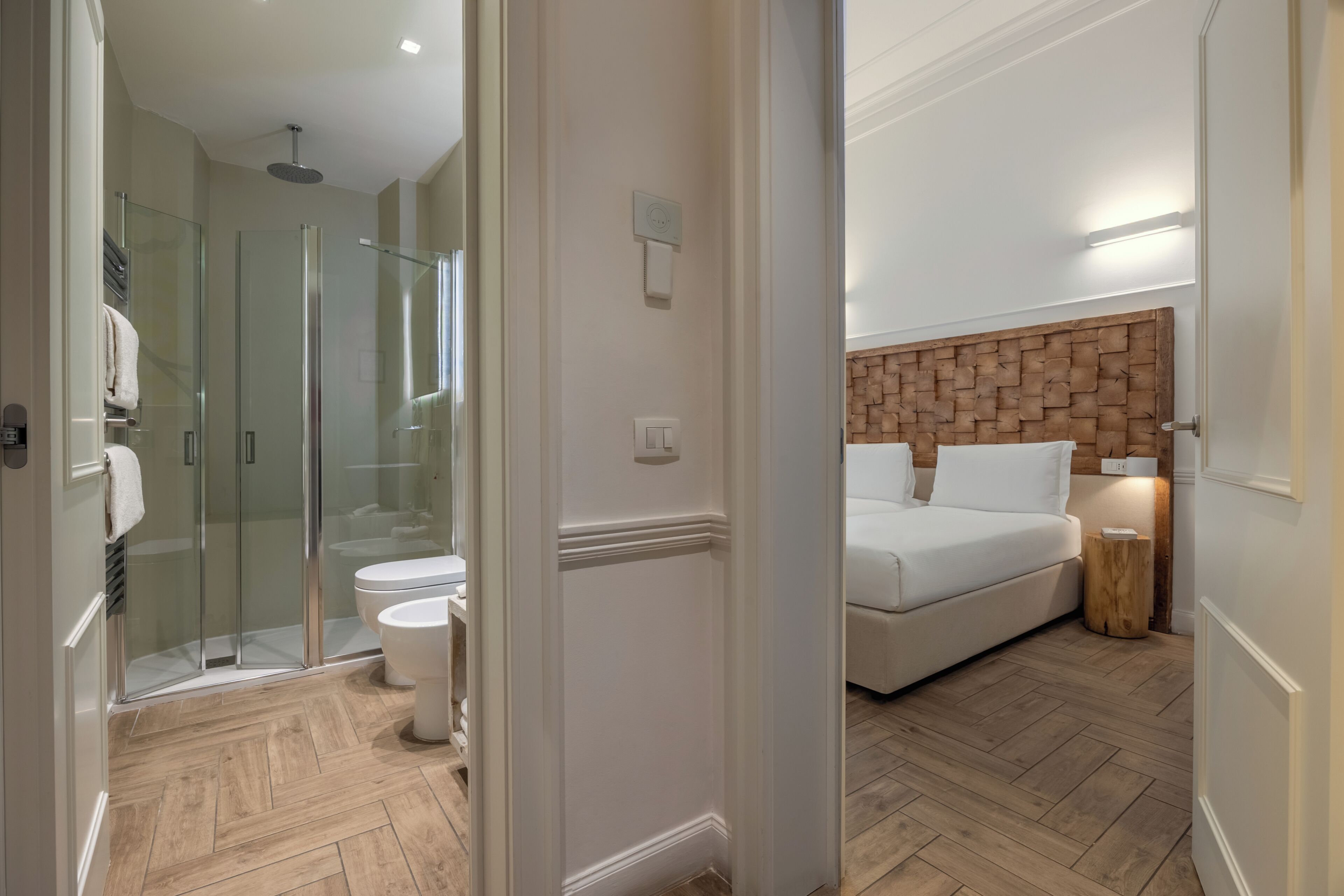 A modern bathroom with a glass shower enclosure, a toilet, and a white sink.