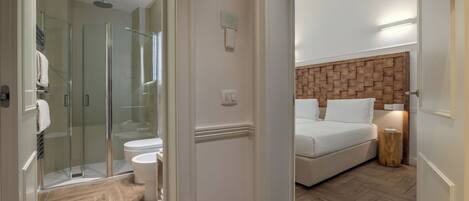 A modern bathroom with a glass shower enclosure, a toilet, and a white sink.