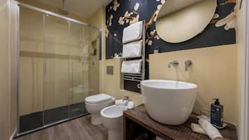 Un baño moderno con cabina de ducha de vidrio, un lavamanos grande y un inodoro.