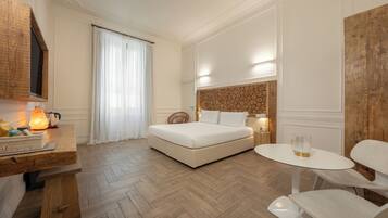 Ein Hotelzimmer mit Bett, Schreibtisch mit Lampe, Stuhl und kleinem Tisch.
