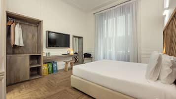 Una habitación de hotel con cama, televisión, escritorio y armario.
