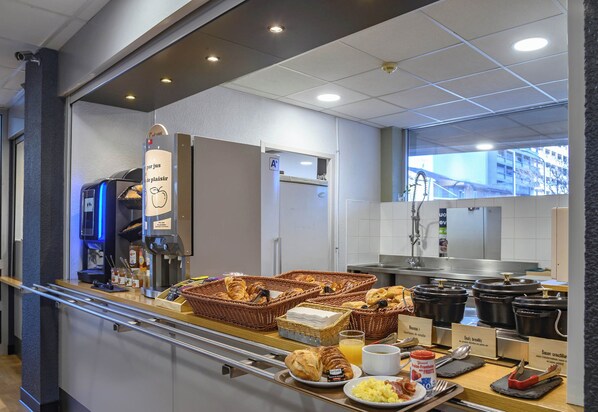 A breakfast buffet with various food items and a coffee machine.