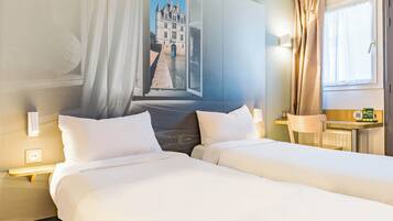 Une chambre d’hôtel avec deux lits, une grande fenêtre avec des rideaux, une horloge murale et une petite table avec une lampe.
