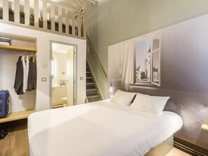 A hotel room with a bed, a wardrobe, a mirror, a bathroom, and a staircase. - B&B Hotel Tours Nord 1 Val De Loire (Tours)