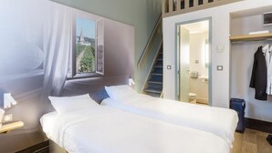 A hotel room with two beds, a window with a view, a staircase, and a coat rack. - B&B Hotel Tours Nord 1 Val De Loire (Tours)
