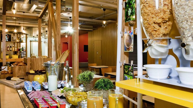Un bufé de desayuno con diversas opciones de comida y bebidas, como pan, bollería y zumo.