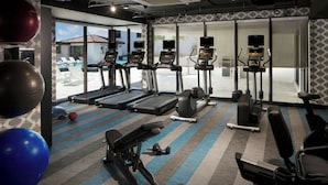 A gym with treadmills, elliptical machines, and exercise balls. - Aloft by Marriott Coral Gables (Coral Gables)