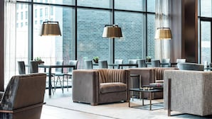 A modern lounge area with large windows, leather sofas, and pendant lighting. - AC Hotel by Marriott Boston Downtown (Boston)