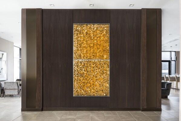 A modern interior with a dark wood panel wall and a central decorative panel. - AC Hotel by Marriott Boston Downtown (Boston)