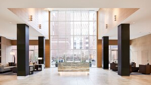 A spacious lobby with a central seating area, large windows, and a modern design.