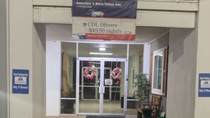 A hotel entrance with a sign advertising 'America's Best Value Inn' and 'CDL Drivers $49.99 nightly'. There are wreaths hanging at the entrance, and a sign indicating 'Hotel Parking Only' with a 15-minute limit. - Americas Best Value Inn Brinkley (Brinkley)