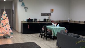 A modern interior with a dining area, a coffee bar, and a Christmas tree. - Americas Best Value Inn Brinkley (Brinkley)