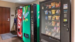 A vending machine with a Coca-Cola logo, a 7UP logo, and a snack vending machine with various snacks. - Comfort Inn & Suites Edgewood (Edgewood)