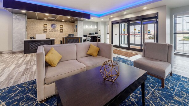 A hotel lobby with a reception desk, a sofa, a chair, and a coffee table. - Comfort Inn & Suites Oklahoma City South I-35 (Oklahoma City)