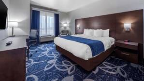 A hotel room with a large bed, a desk with a chair, a television, and a window with curtains. - Comfort Inn & Suites Oklahoma City South I-35 (Oklahoma City)