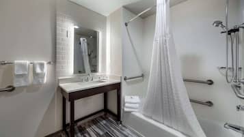 A modern bathroom with a shower, a sink, and a mirror.