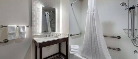 Ein modernes Badezimmer mit Dusche, Waschbecken und Spiegel.
