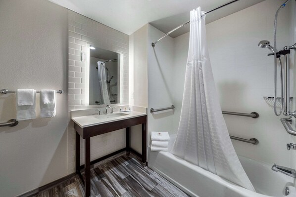 Un baño moderno con ducha, lavamanos y espejo.