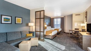 A hotel room with a sofa, a bed, a desk, and a computer. - Comfort Inn & Suites Salt Lake City Airport (Salt Lake City)