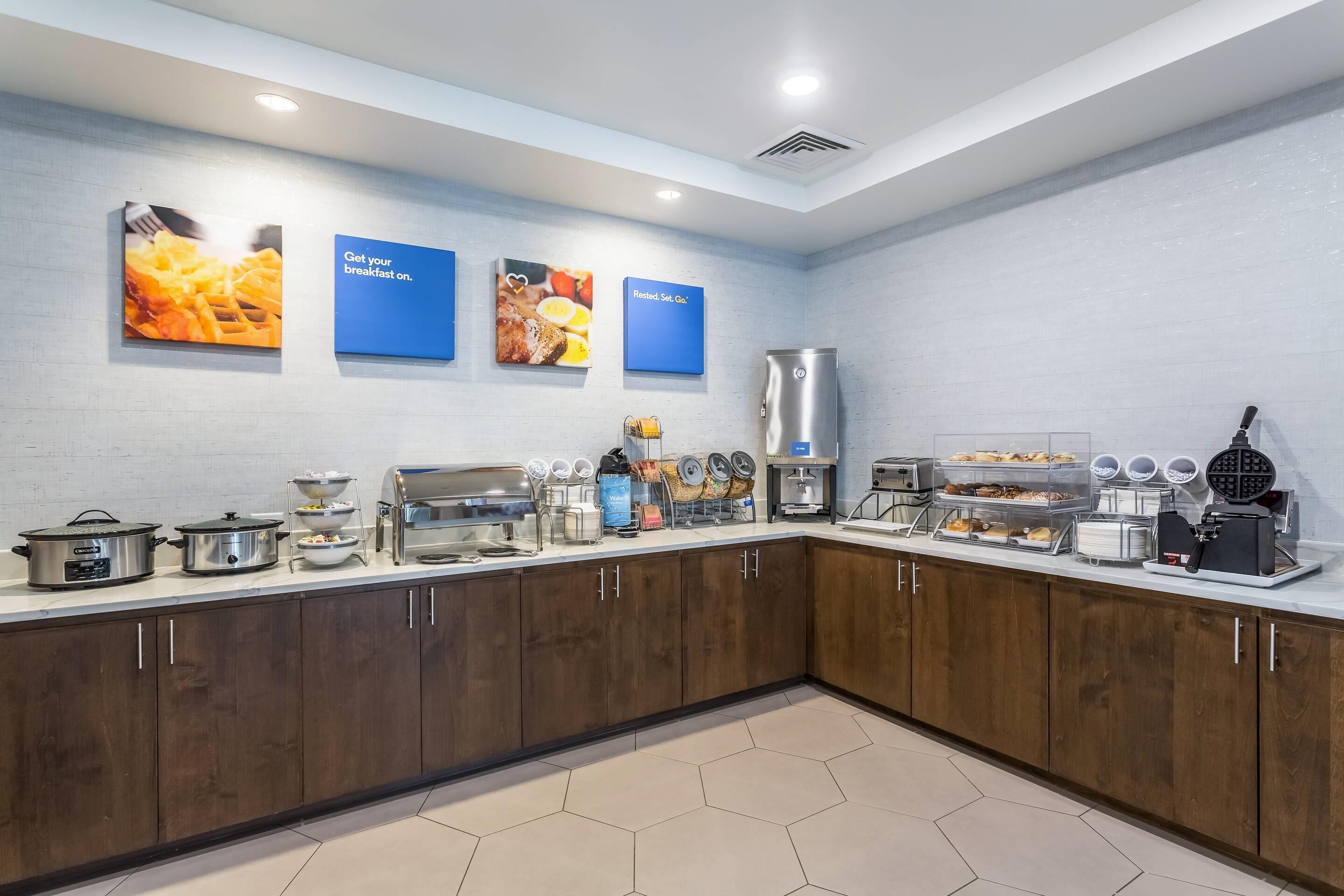 A breakfast buffet area with various food items and cooking equipment.