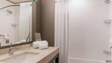 Ein modernes Badezimmer mit Waschbecken, Spiegel, Dusche und Badewanne.