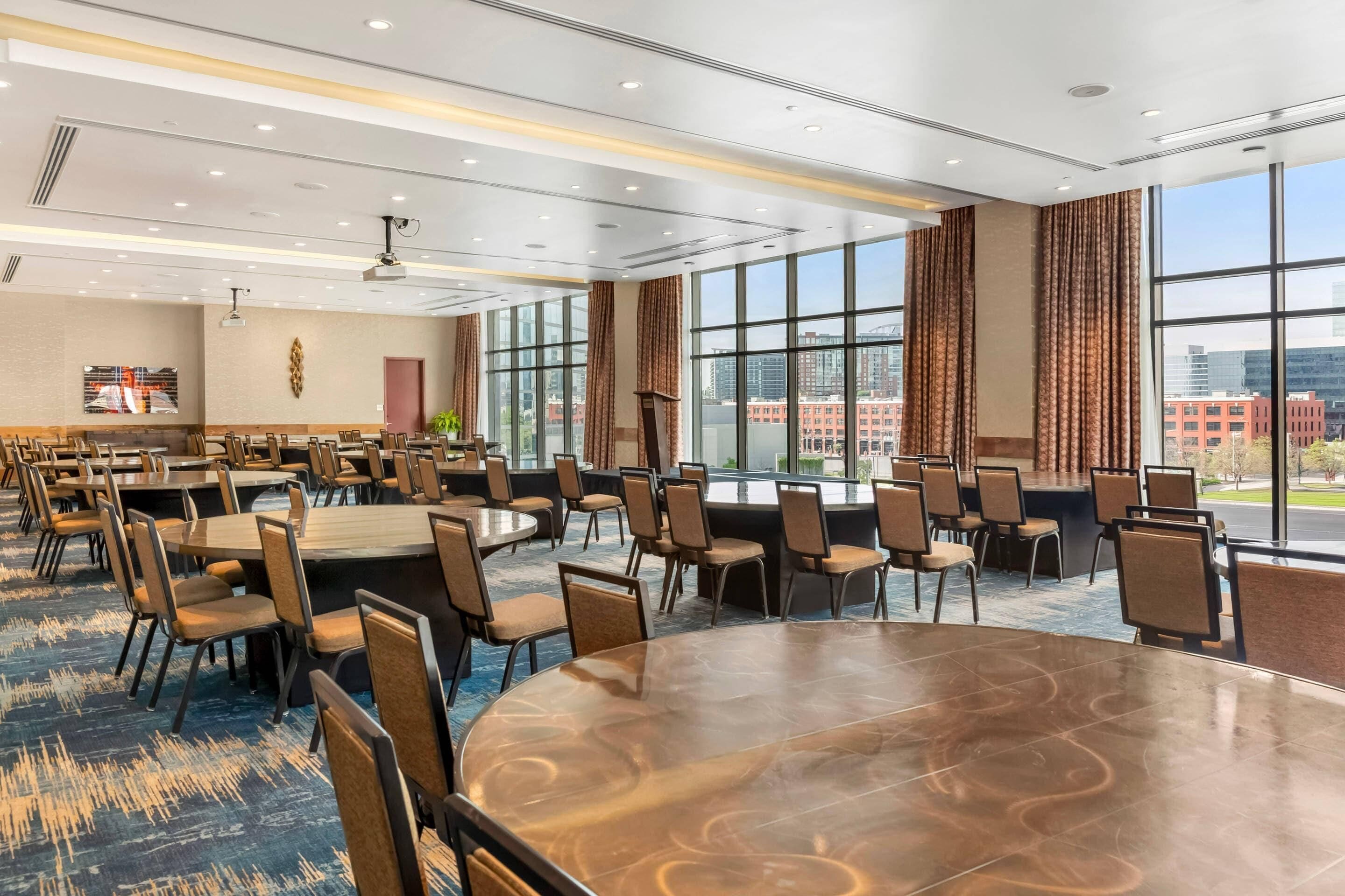 Une salle de conférence dotée d’une grande table, de chaises et offrant une vue sur les bâtiments grâce à de larges fenêtres.