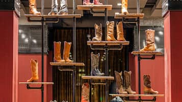 A display of boots suspended on metal racks in a retail setting.