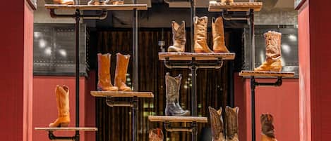 A display of boots suspended on metal racks in a retail setting.