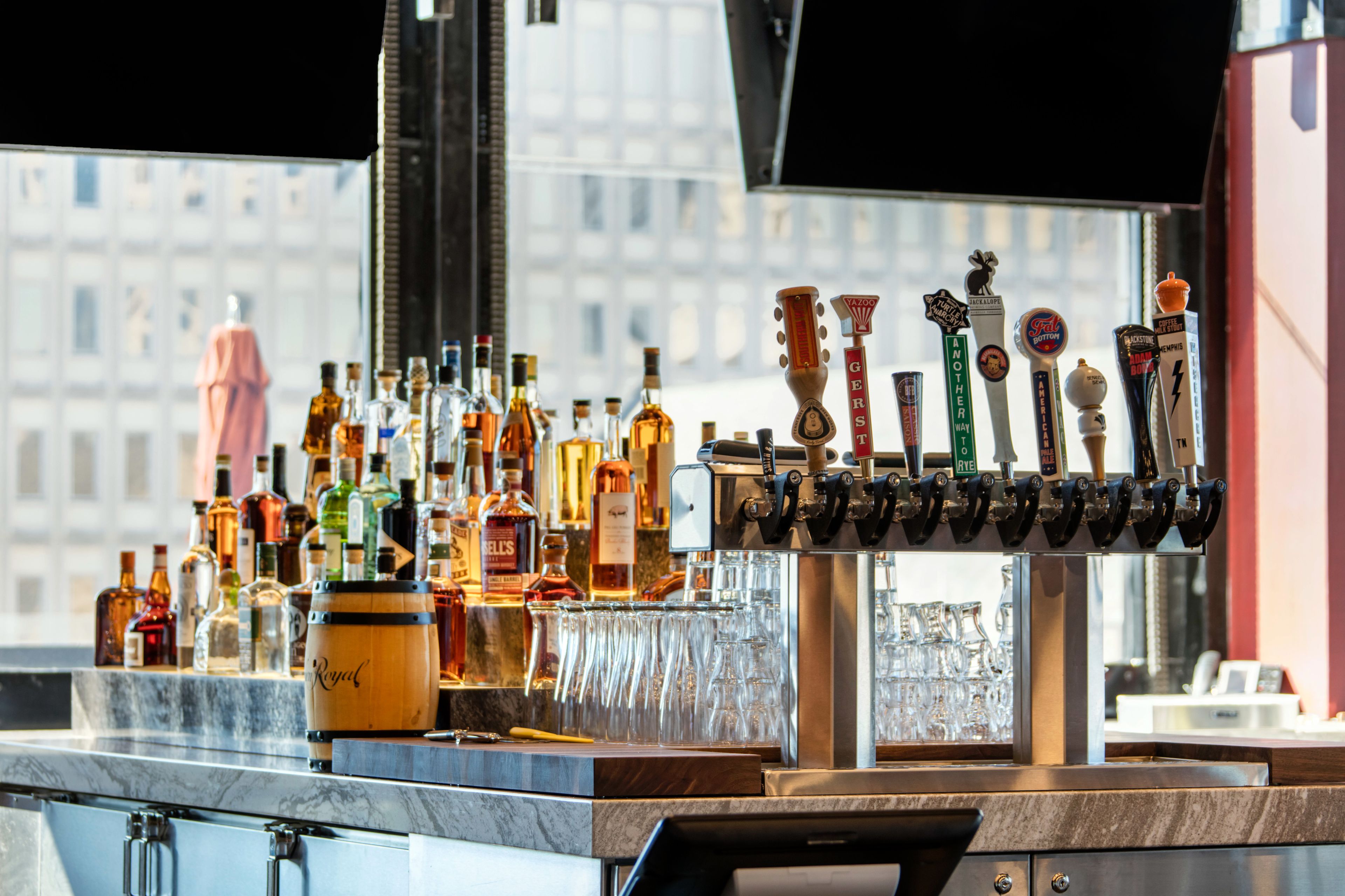 Un espace bar avec un assortiment de bouteilles d’alcool et un système de distribution en fût.