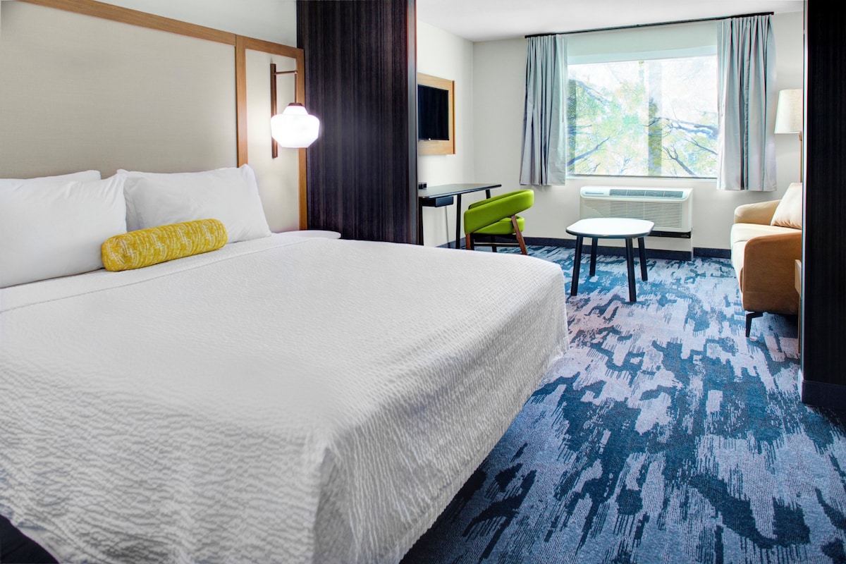 Een hotelkamer met een groot bed, een bureau, een stoel en een bank.