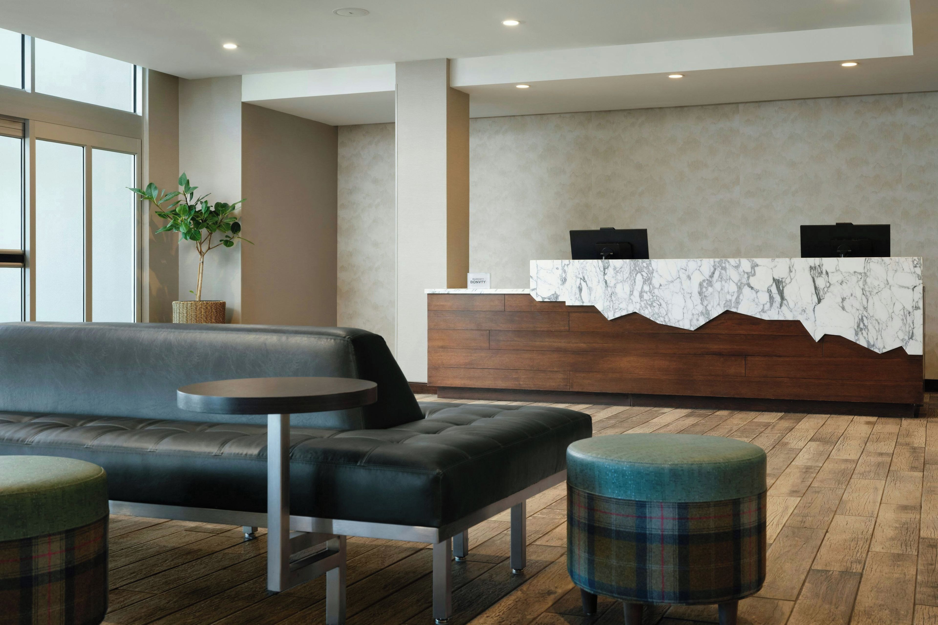 A reception area with a marble counter, a sofa, and a small table.